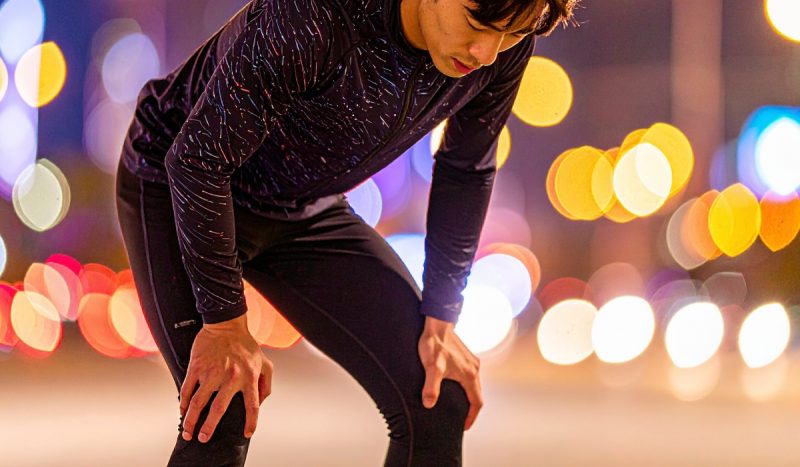 膝を抱えて挫折するランナー